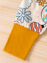 Baby one-piece with playful holiday print and mustard yellow sleeve.