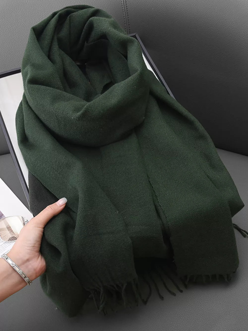 Dark green scarf with fringe detail, soft texture, versatile styling