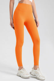 Orange high-waist performance leggings with sculpting seams.