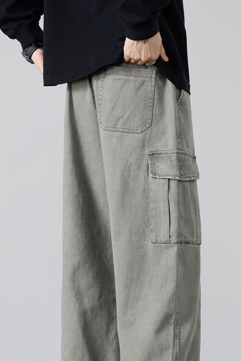 Gray relaxed fit cargo sweatpants with drawstring and button-flap cargo pocket.