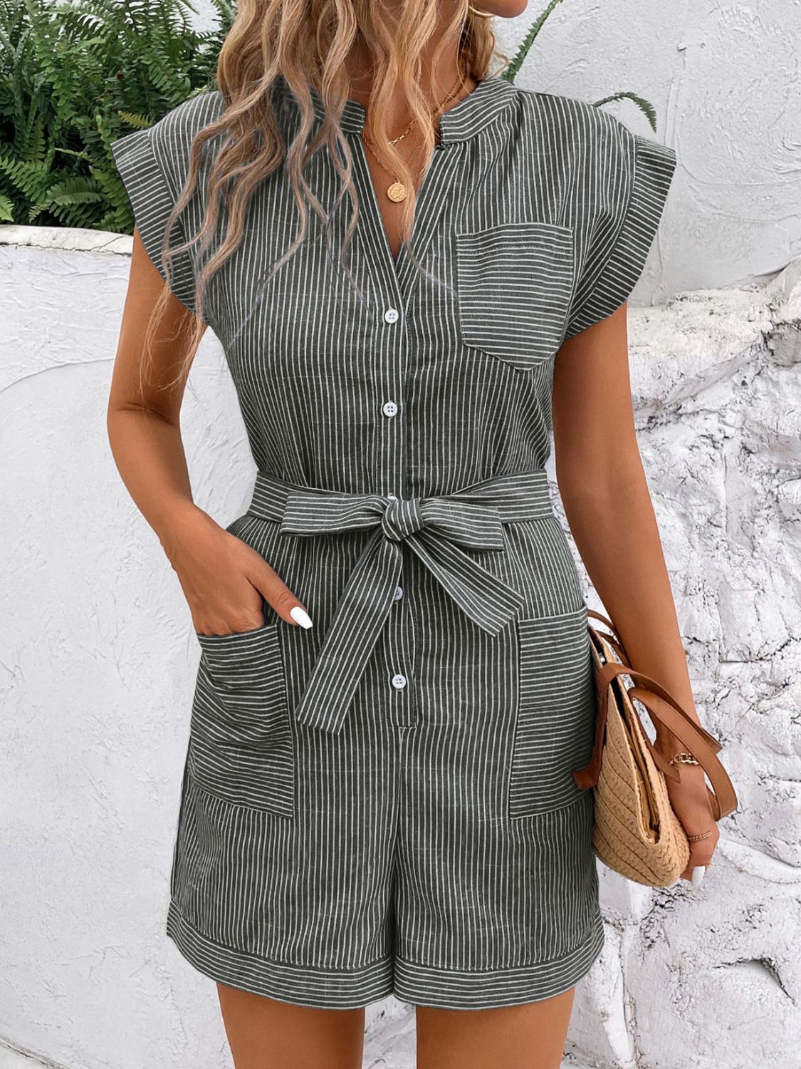Striped shiriting romper in Gum Leaf with a tie waist, button front, and chest and hip pockets.