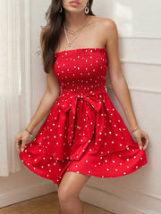 Red smocked strapless mini dress with white hearts and a bow tie waist.