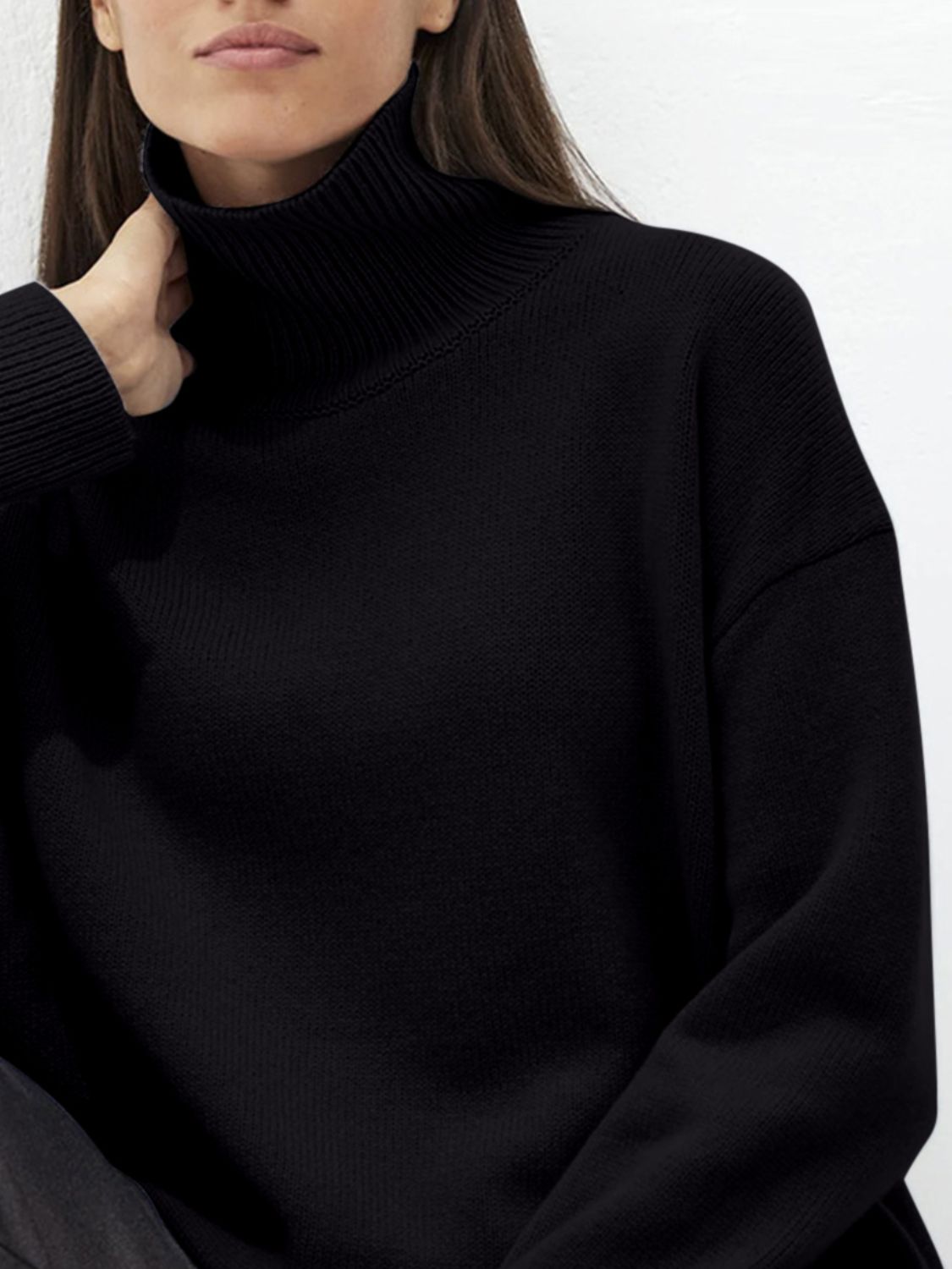 Black acrylic turtleneck sweater with sculptural sleeves and ribbed cuffs.