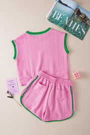 Pink cable knit loungewear set with green trim, sleeveless top and shorts.