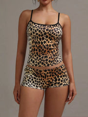Women's leopard print cami and shorts pajama set with black trim.