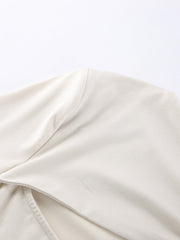 Beige long-sleeve shirt with knot front detail and cutout.