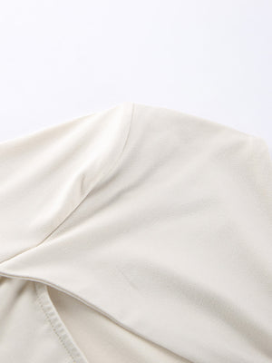 Beige long-sleeve shirt with knot front detail and cutout.