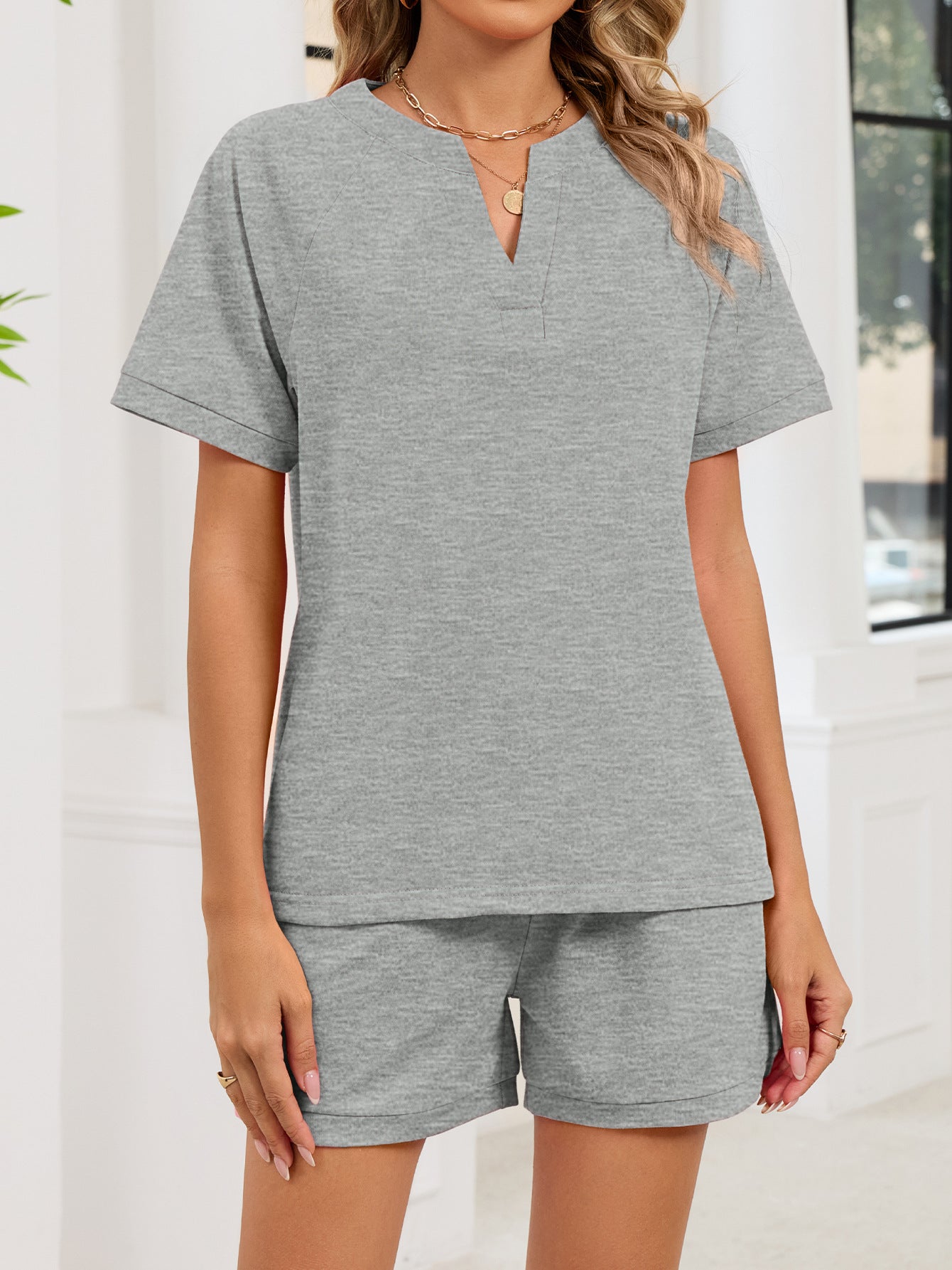 Gray two-piece loungewear set with a notched V-neck top and drawstring shorts.