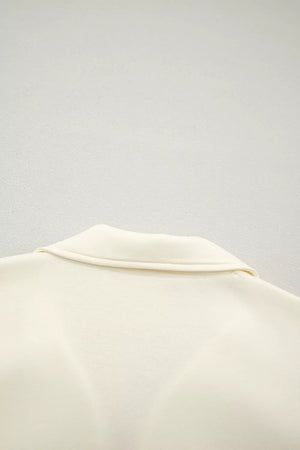 Cream cotton blouse with stand-up collar and ruffled detail