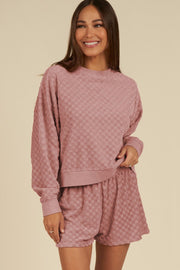 Dusty pink textured checkered lounge set with crewneck sweatshirt and shorts.