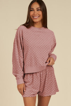 Dusty pink textured checkered lounge set with crewneck sweatshirt and shorts.
