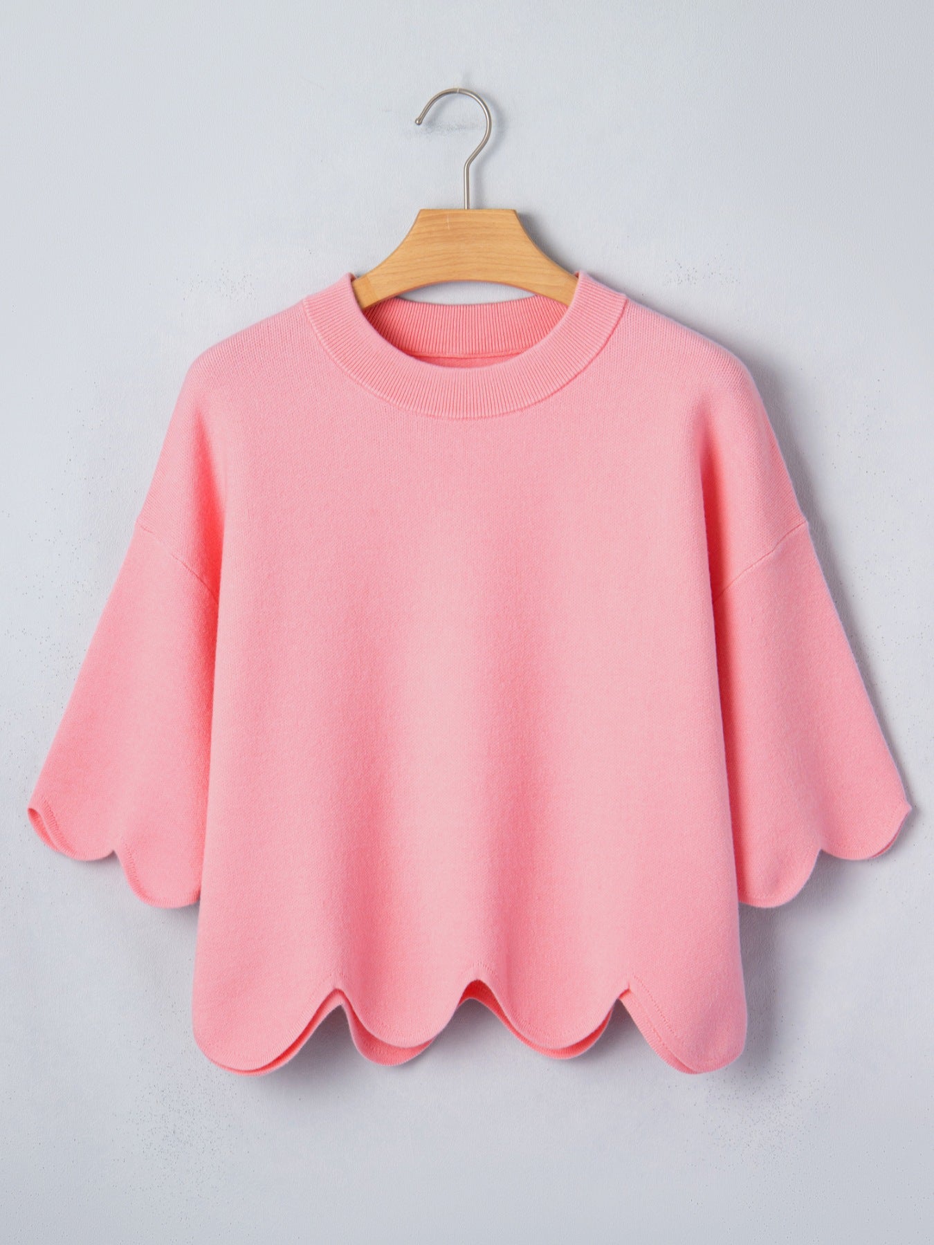 Pink knit top with scalloped hem and sleeves