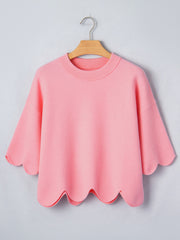 Pink knit top with scalloped hem and sleeves