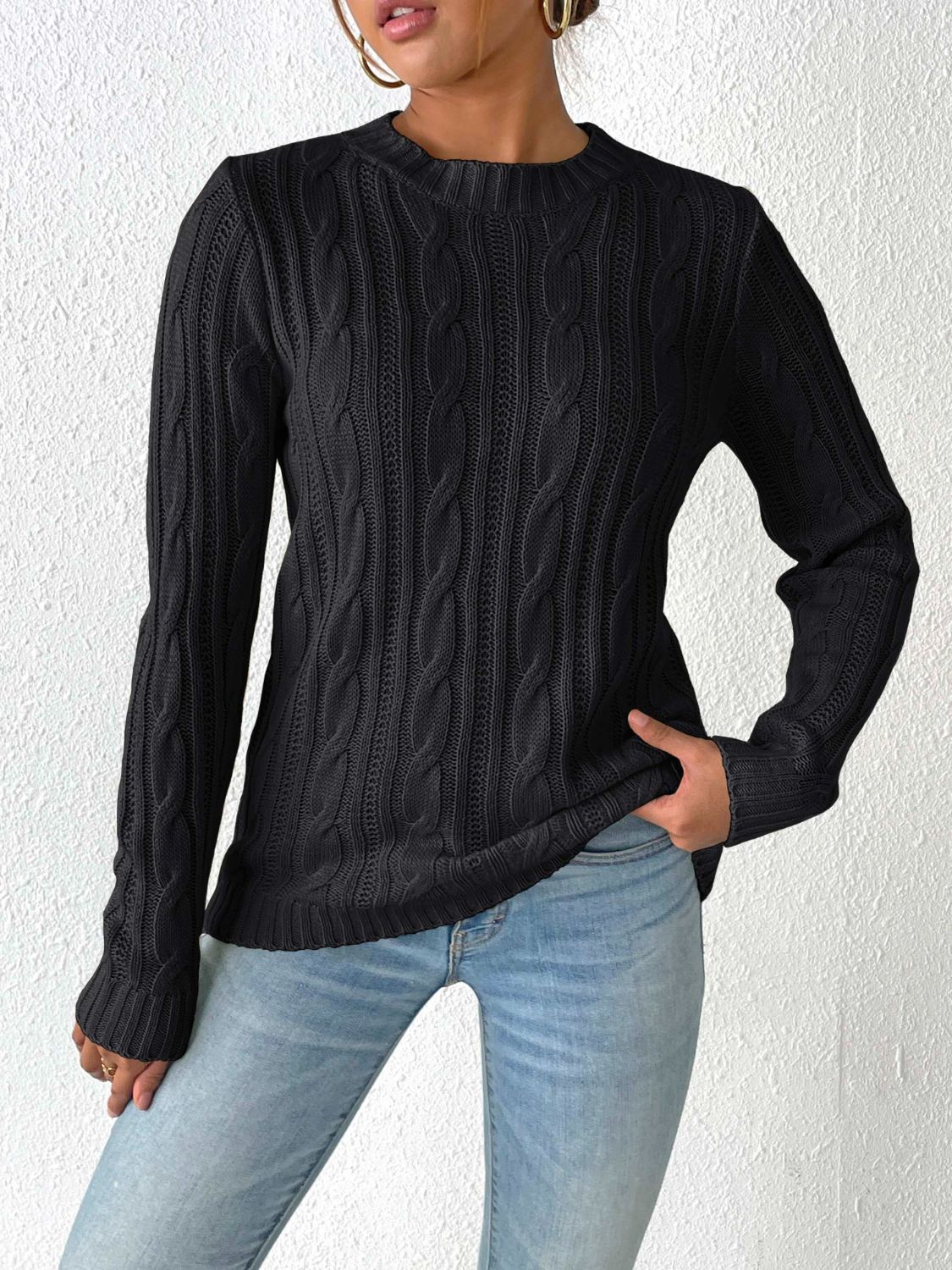 Black cable knit mock neck sweater with long sleeves and textured detail.