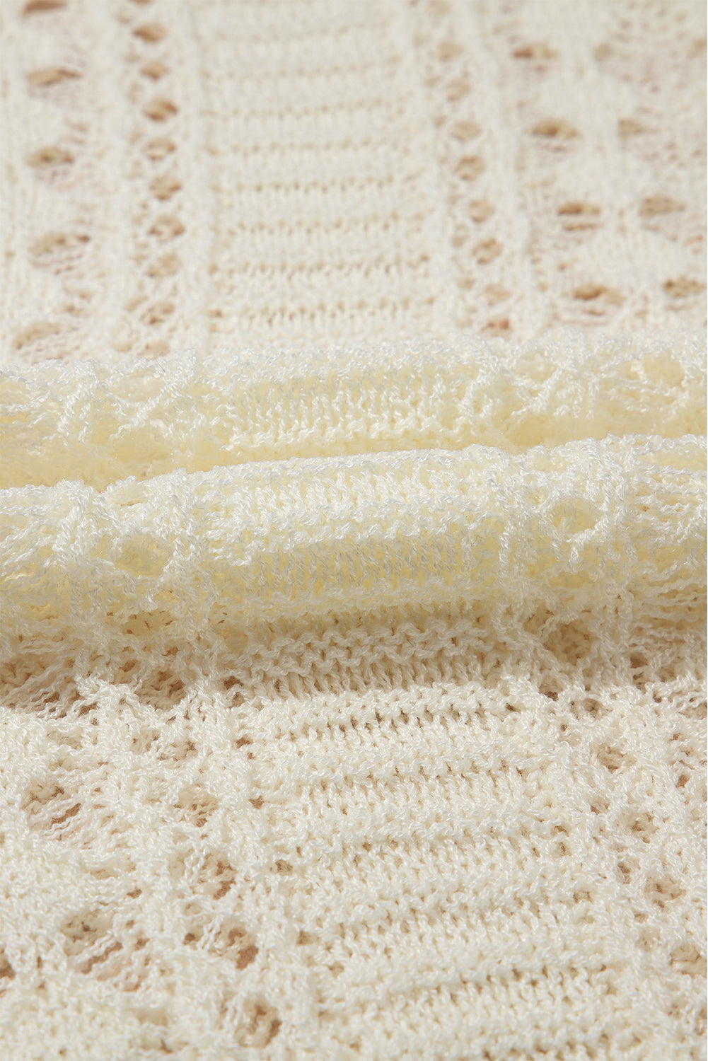 Beige openwork knit beach cover-up with intricate lace-like details.