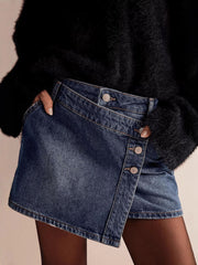 Dark blue denim skort with asymmetrical button-front detail and frayed hem