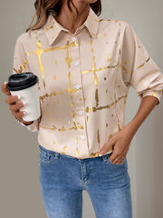 Tan blouse with gold brushstroke print and gathered sleeves.