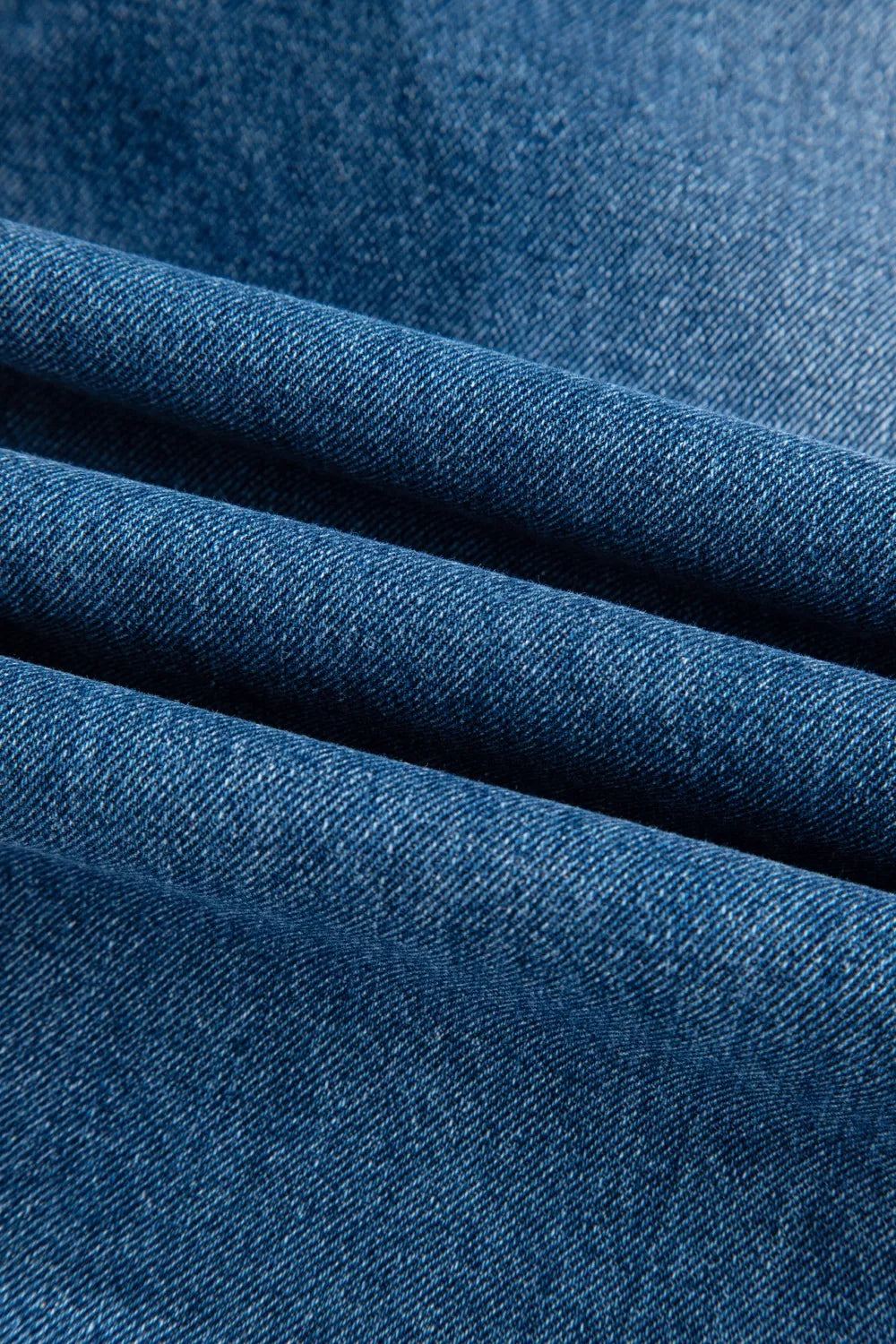 Denim overalls in a medium blue wash with a visible twill weave texture.