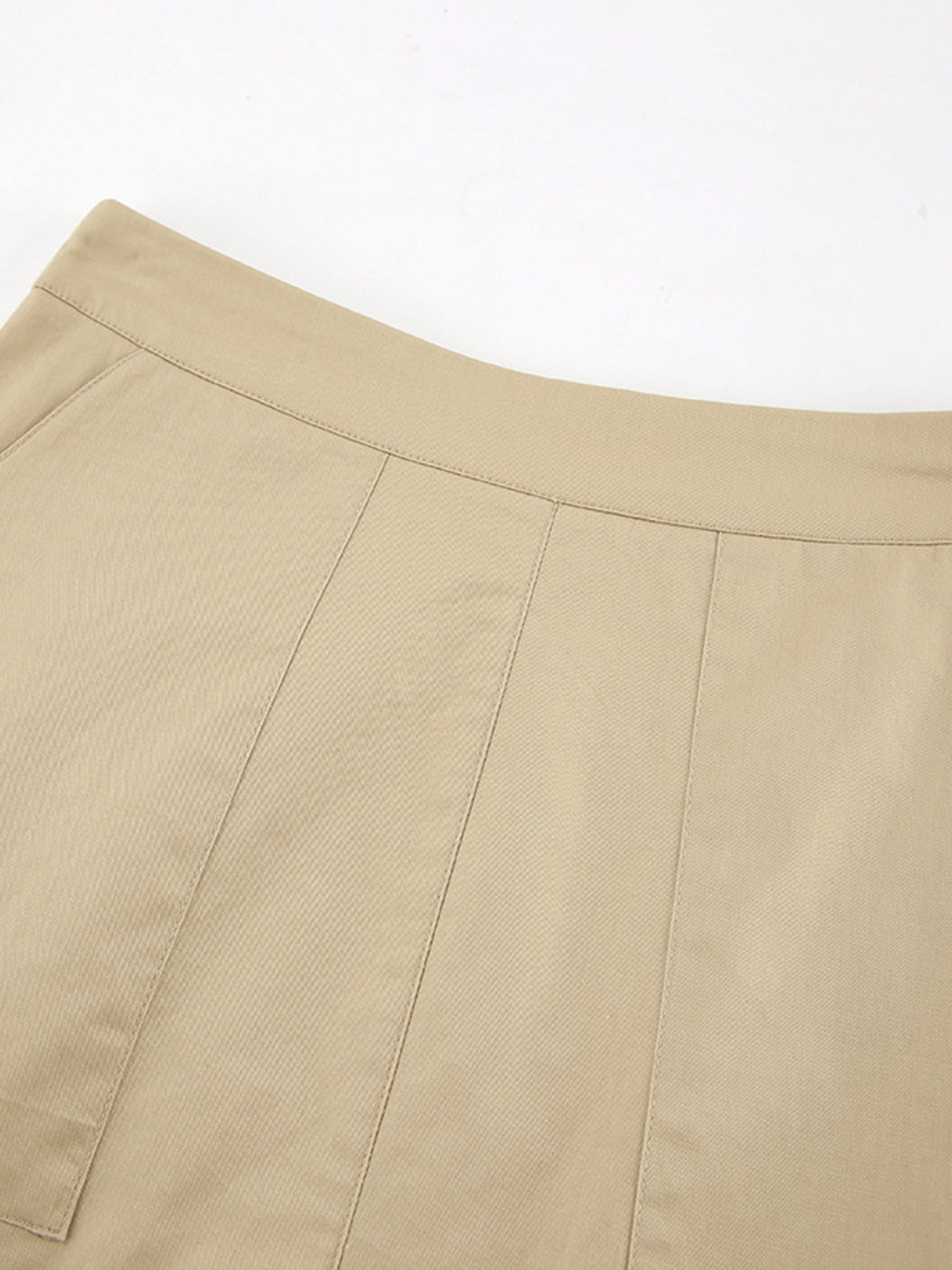 High-waisted beige cotton A-line skirt with pockets and stitched panel details.