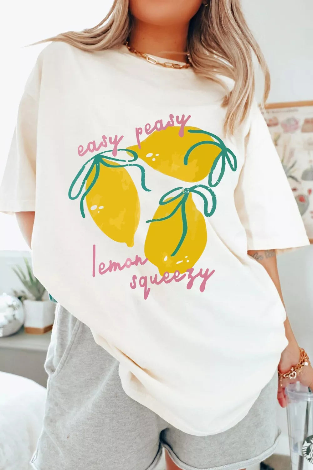 Cream polyester t-shirt with a graphic of three lemons and text that says "easy peasy lemon squeezy".