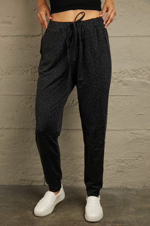 Black shadow leopard relaxed-fit drawstring trousers with elastic waistband and cuffed ankles.