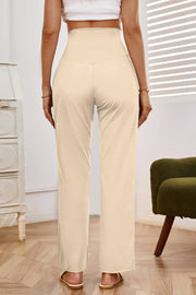 High-waisted flare leg trousers in tan with a V-shaped waistband detail.
