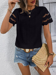 Black eyelet blouse with scalloped short sleeves and intricate cutout details.