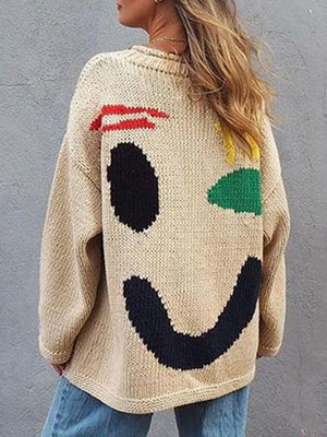 Tan knit sweater with a playful abstract smiley face graphic on the back.