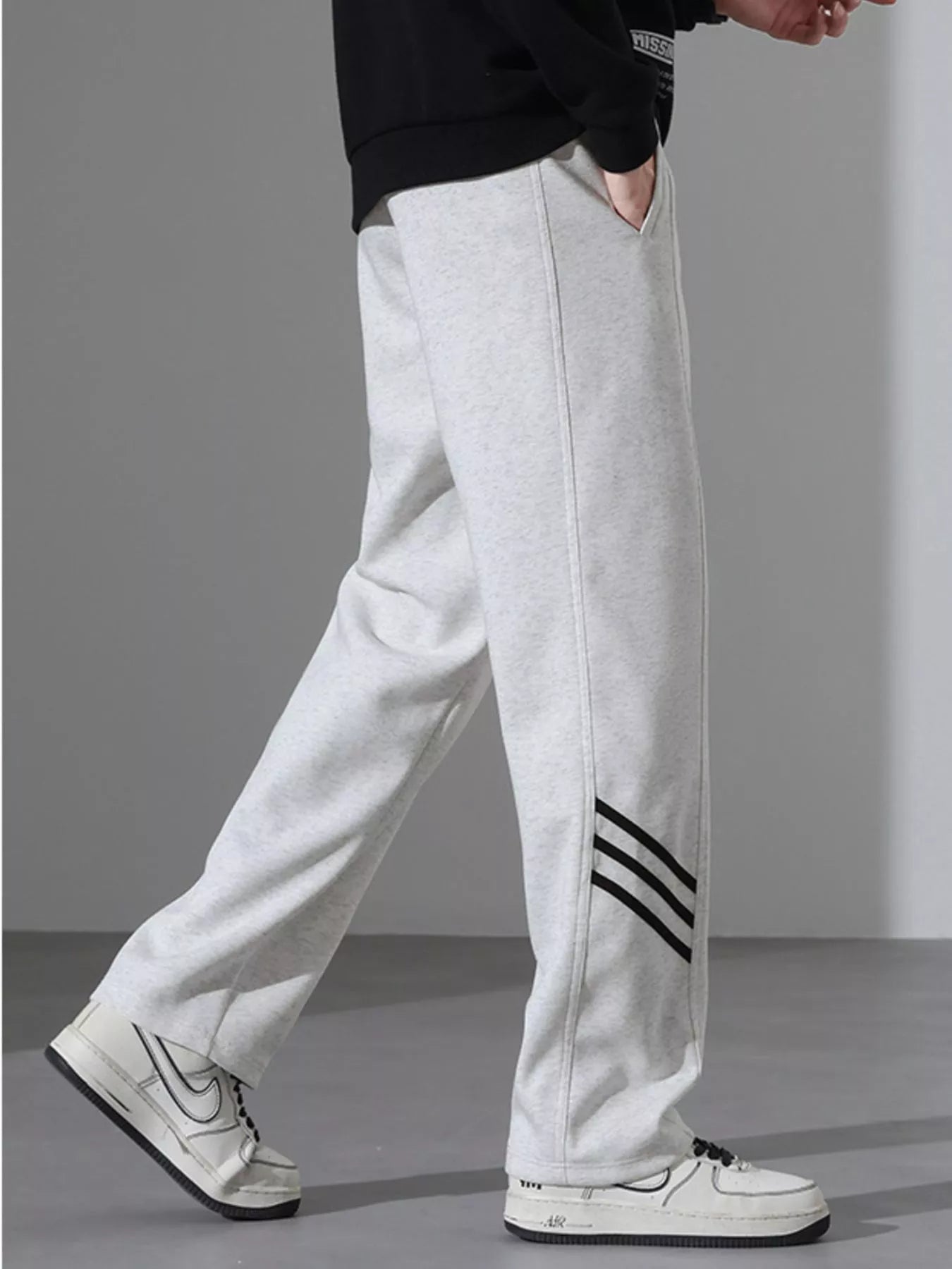 Light Flower Gray sweatpants with black side stripes and a loose fit.