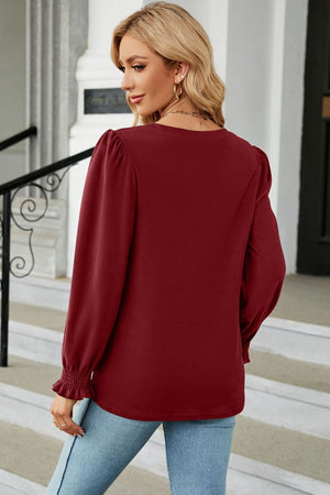 Crimson ribbed cuff top with puff sleeves and smocked cuffs.