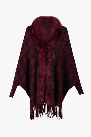 Burgundy houndstooth poncho with faux fur collar and fringe detail.