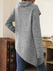 Gray knit asymmetric sweater with cowl neck and diagonal button detail.