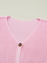 Pink acrylic button front V neck sweater vest with ribbed texture.
