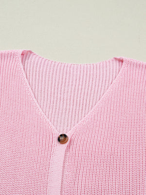 Pink acrylic button front V neck sweater vest with ribbed texture.