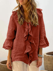 Ruffled linen blouse in orange-red with flared sleeves and V-neck.