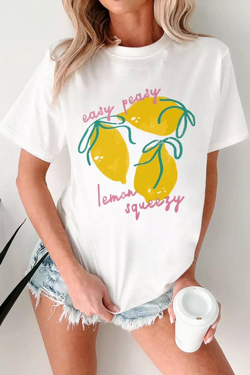 White polyester t-shirt with a cheerful lemon graphic and text that says easy peasy lemon squeezy.
