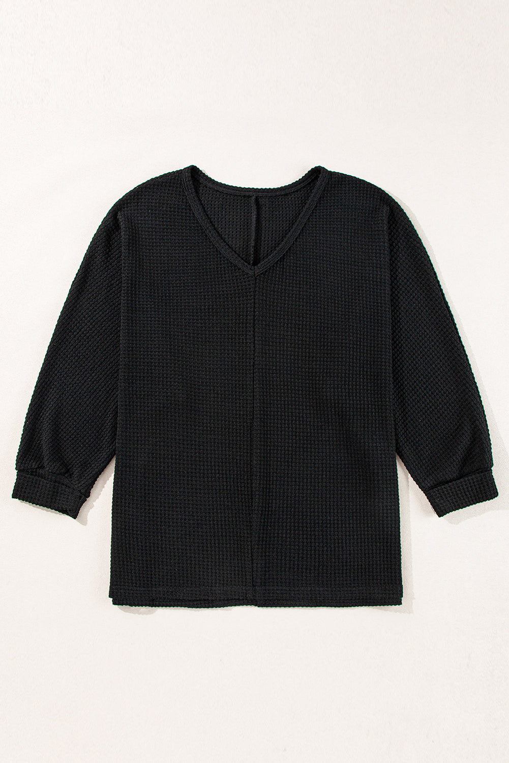 Black waffle knit V-neck long sleeve top with slit hem detail.