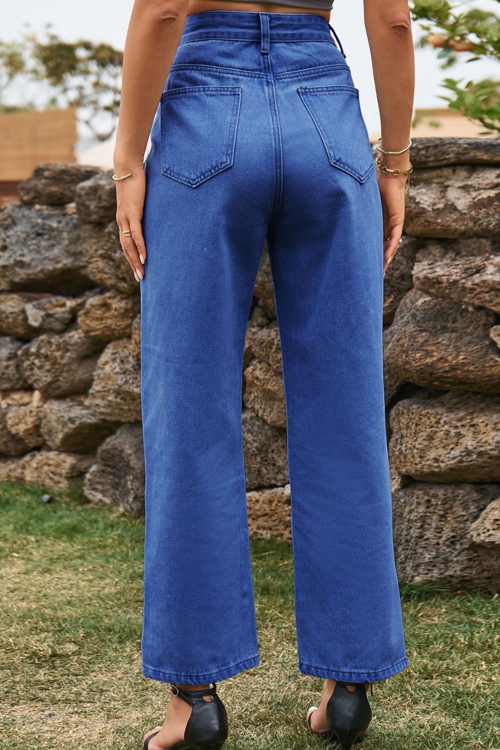 Medium wash denim jeans with a straight leg and split hem detail.