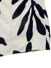 Tropical leaf print belted dress in ivory and navy, showing fabric detail.