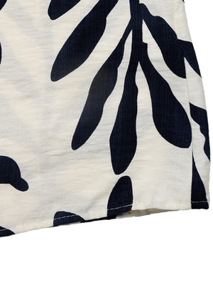 Tropical leaf print belted dress in ivory and navy, showing fabric detail.