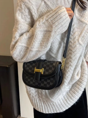 Chic monogrammed flap crossbody bag in black with gold hardware and a leather strap.