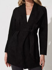 Black suede duster coat with tie waist and open collar, worn by a woman.