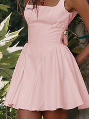 Blush pink backless mini dress with square neckline and bow detail.