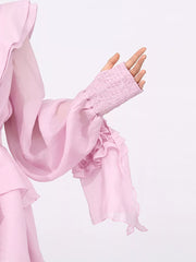 Pink tiered ruffle mini dress with smocked cuffs and flowing sleeves.