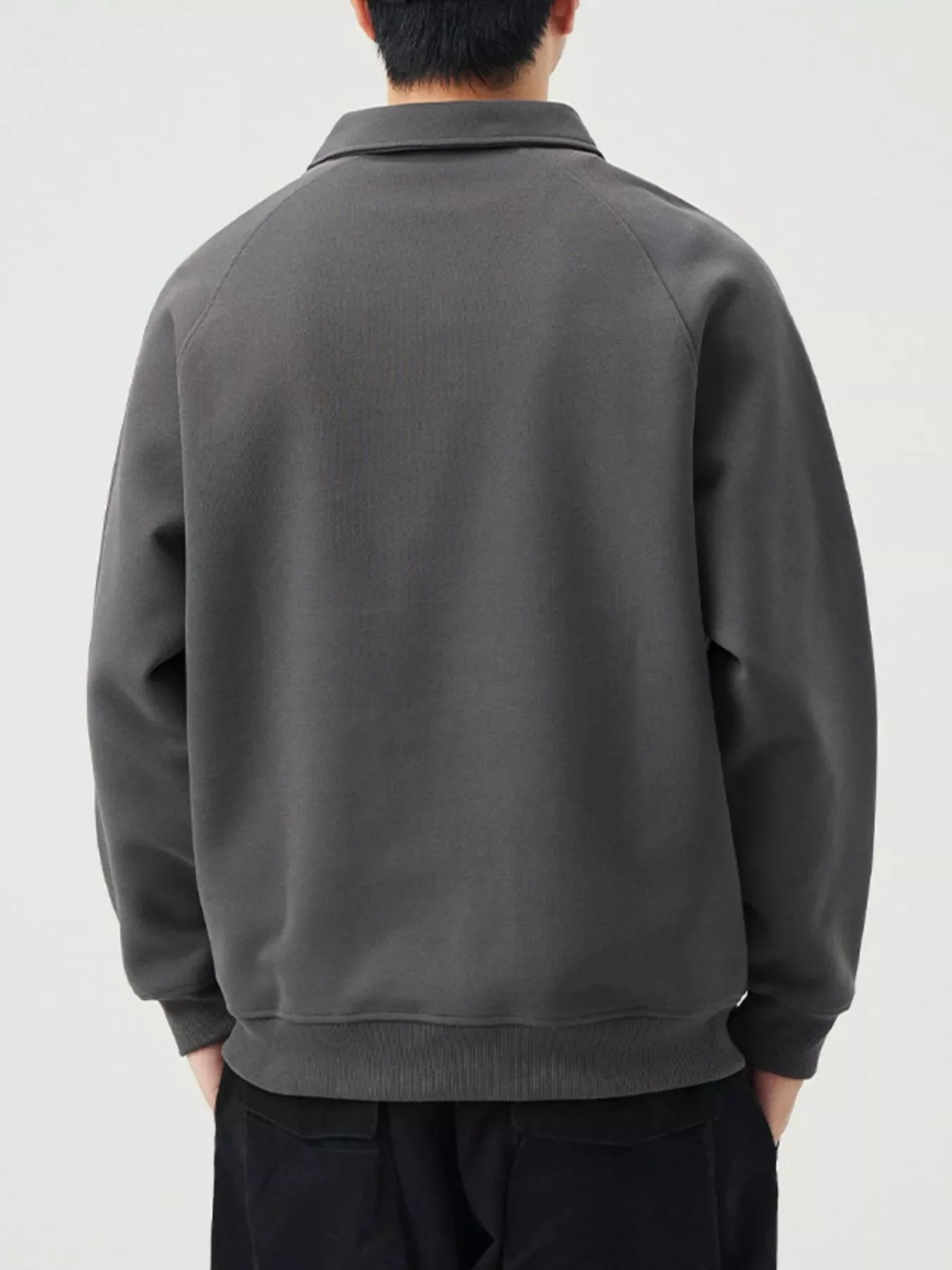 Dark gray raglan quarter zip sweatshirt with a collared neckline and ribbed cuffs and hem.