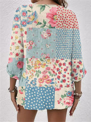 Printed V-neck blouse with a colorful floral patchwork design and 3/4 sleeves.