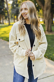 Cream fleece shirt jacket with patch pockets and black buttons.