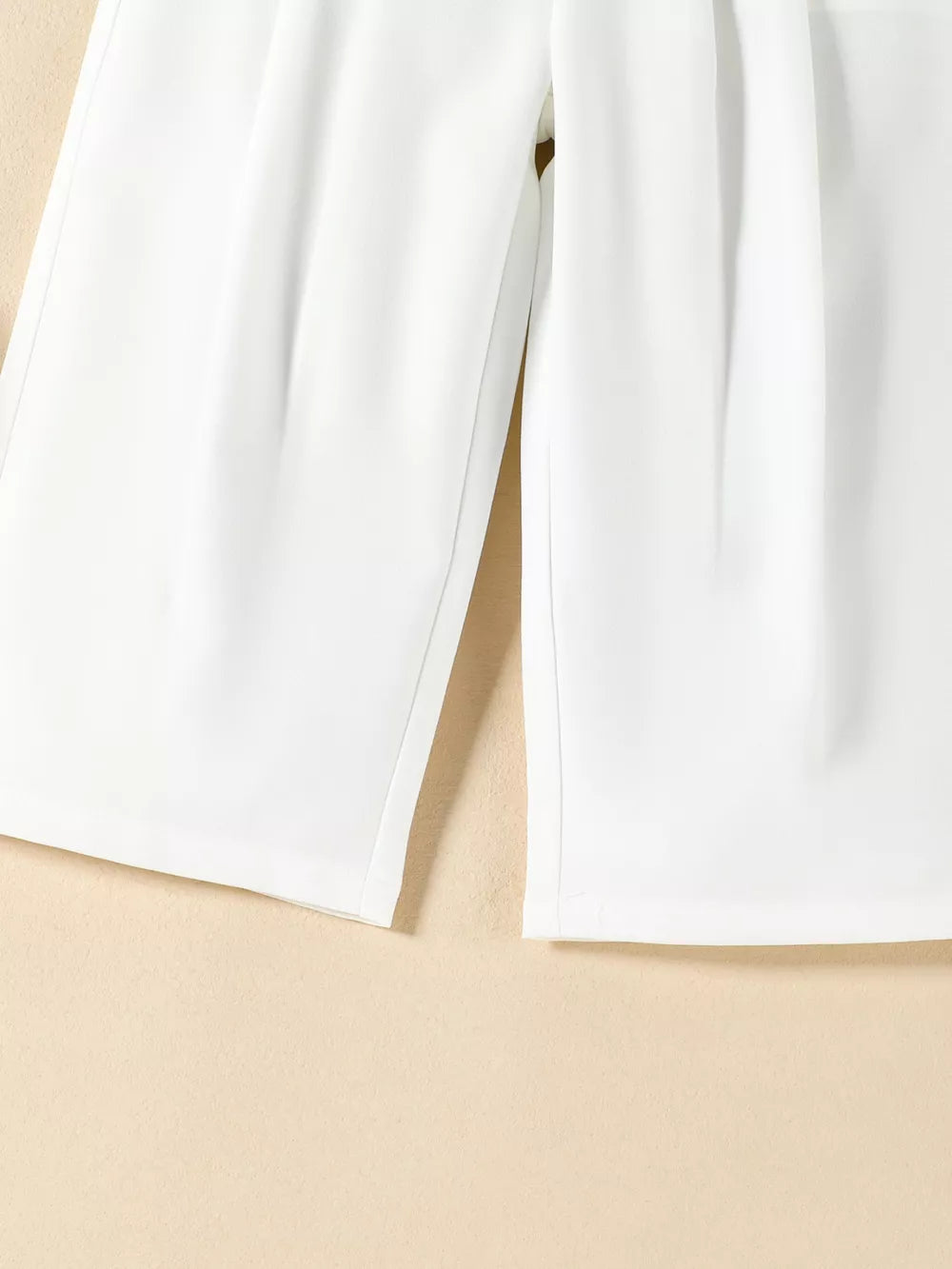 White baby outfit with pleated detail on pants