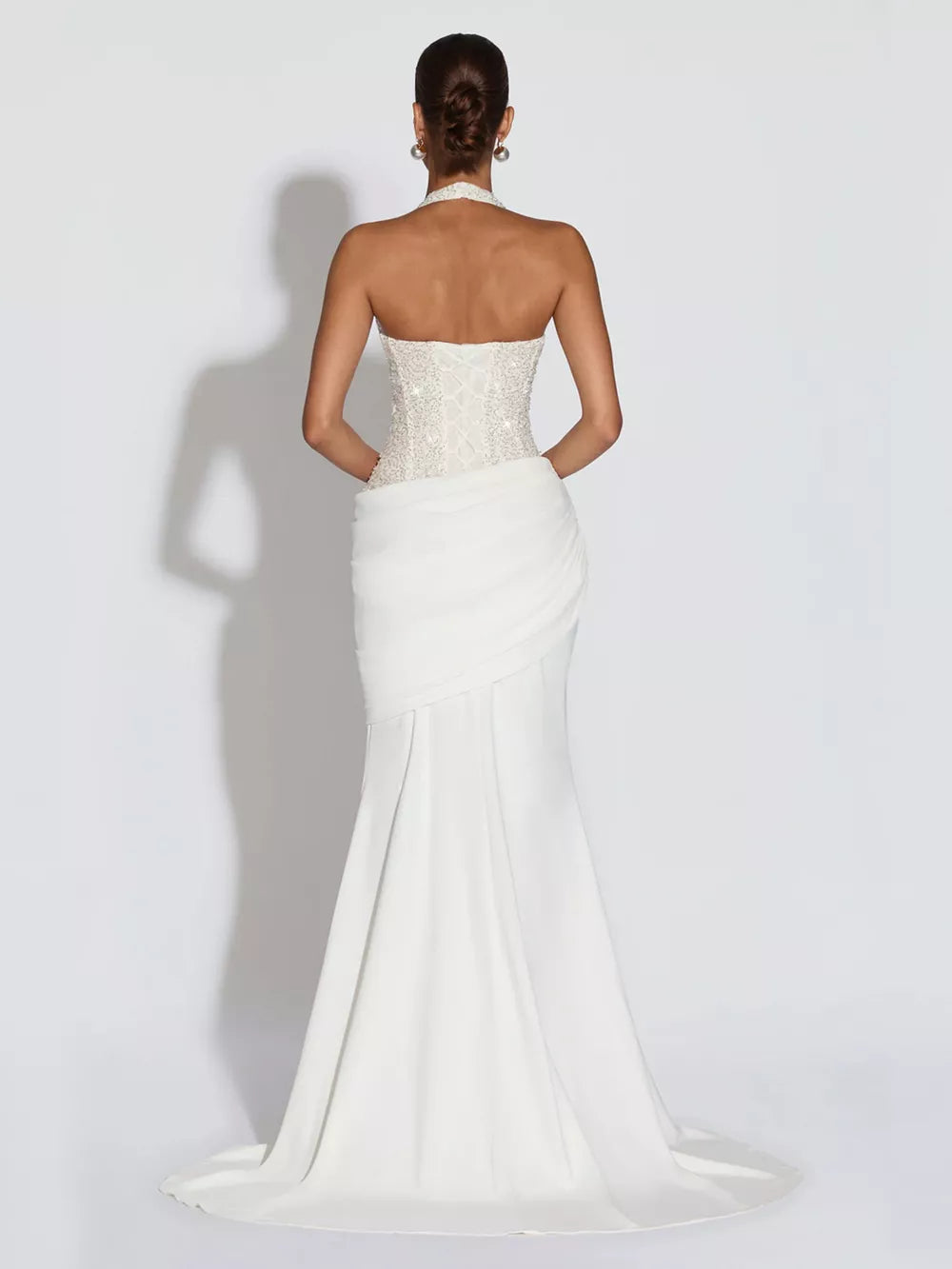 White sequin halter neck maxi gown with corset back and draped skirt.