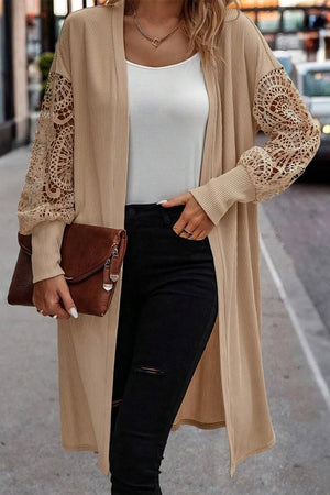 Tan ribbed knit duster cardigan with intricate lace sleeves and a longline cut.